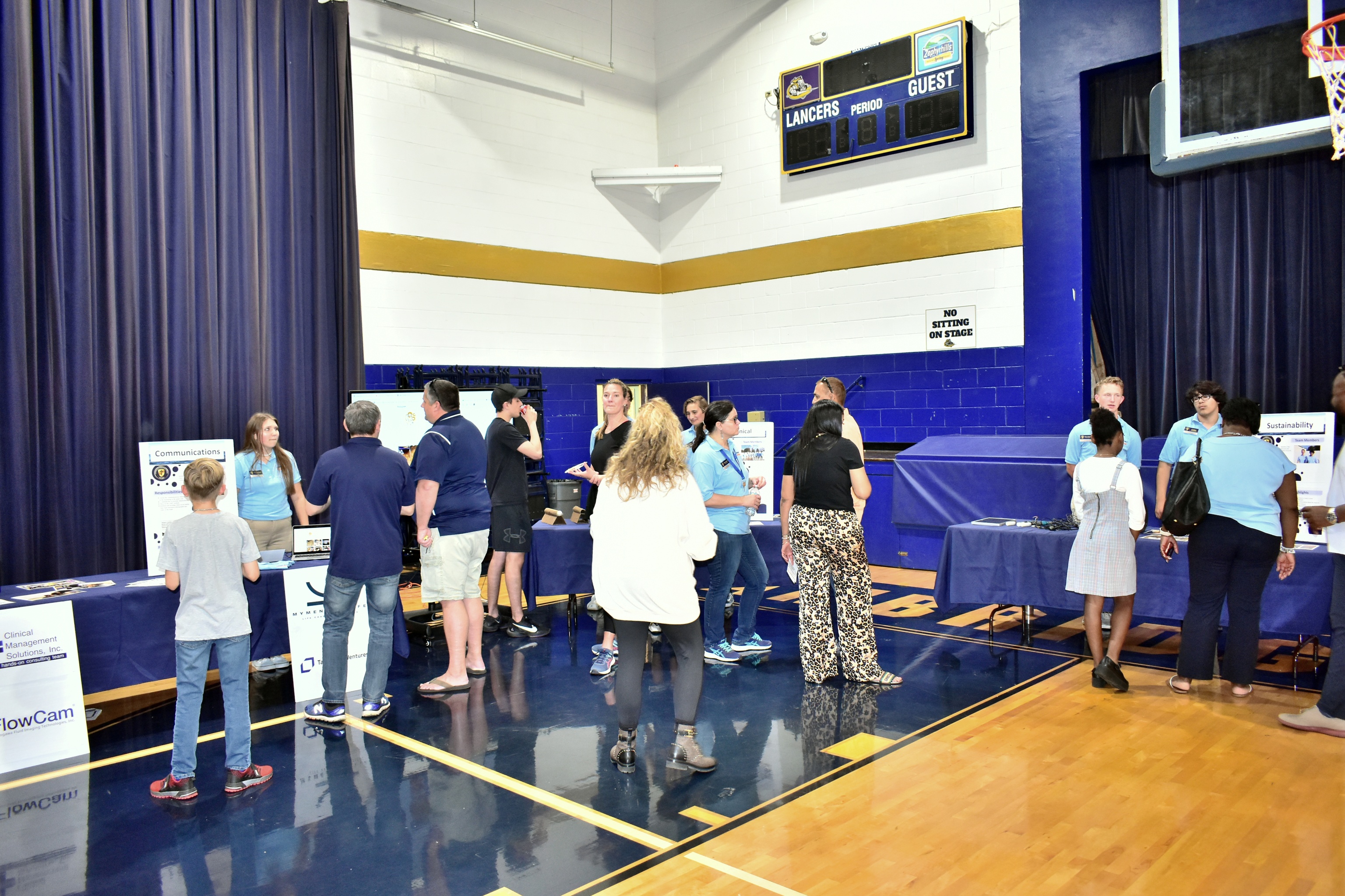 A group of people view various tables.